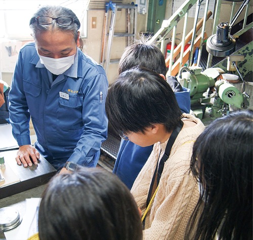 金属加工の説明を受ける児童