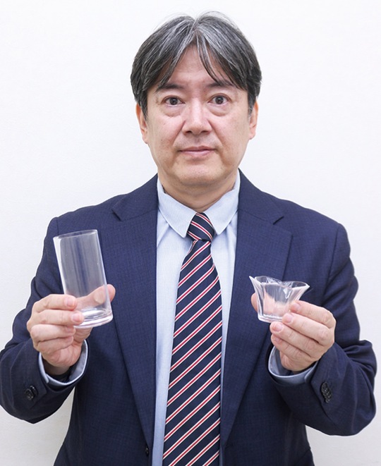 吸着したCO２を原料に作成したガラス製品を手にする山本代表