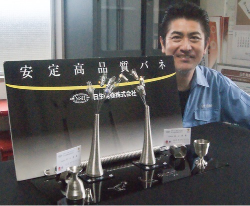 「生けバネ」と「恐竜型クリップ」について説明する武山専務取締役