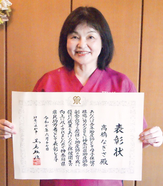 表彰状を持つ高橋さん