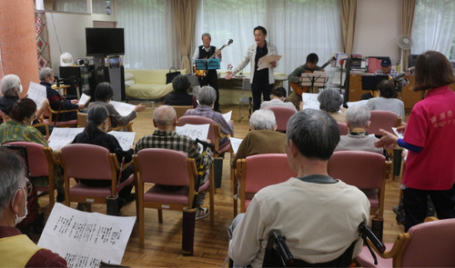 バーンズと一緒に歌う利用者ら