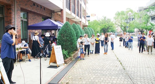 ハーモニカの演奏に耳を傾ける来場者