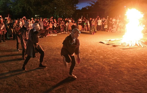 松明を集めた御焚上げの周りを舞う獅子とひょっとこ