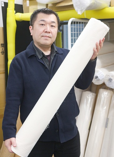 シーチングを手にする堀内代表