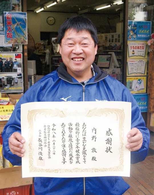 表彰状を手に笑顔の内野さん