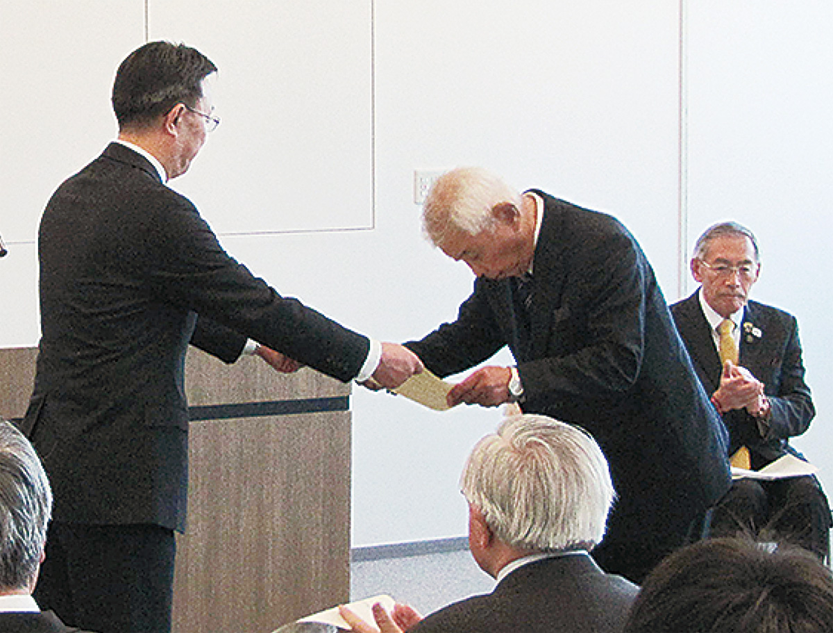 区長（左）から表彰状を受け取る功労者