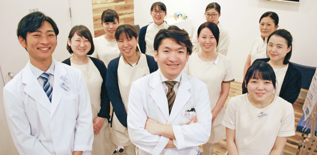 清潔に保たれた院内で笑顔を浮かべる天雲理事長（前列中央）とスタッフ