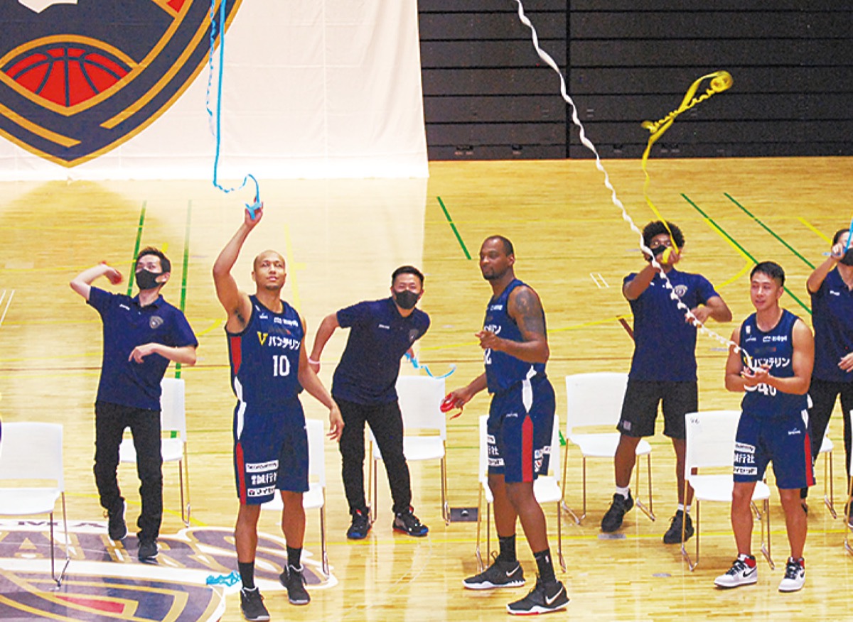 紙テープを投げ入れる選手ら