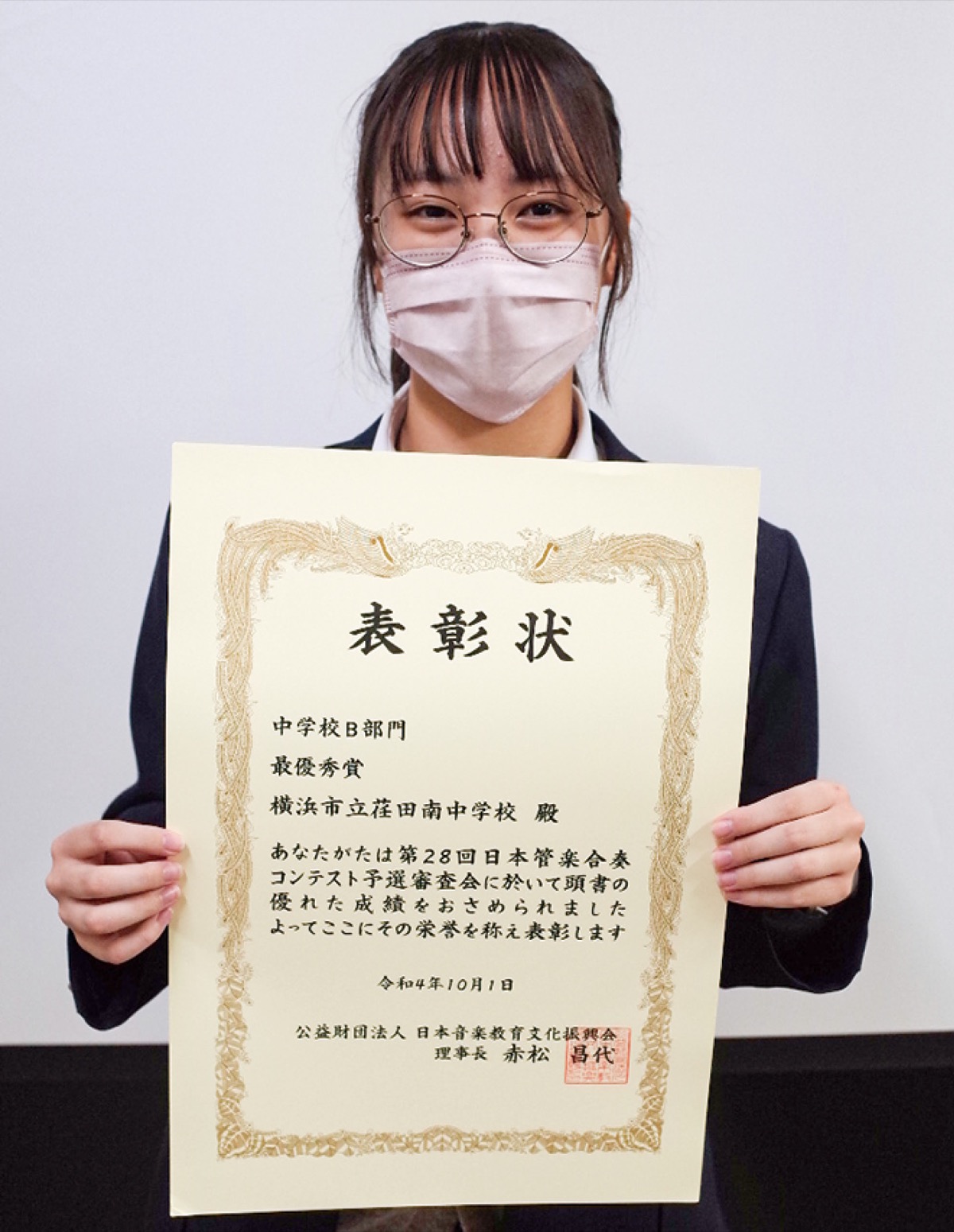 賞状を手に笑顔の部長・片倉さん