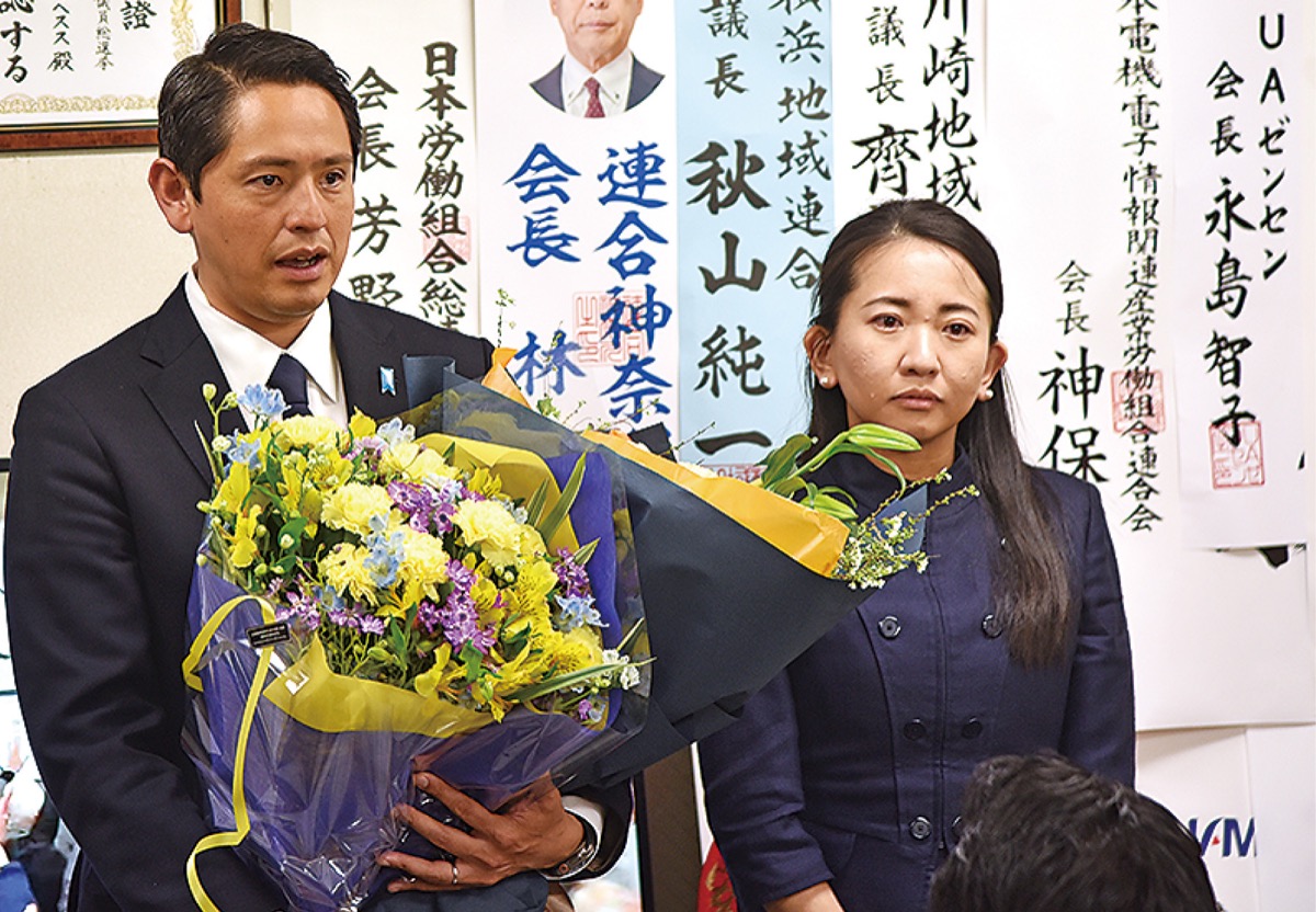 花束を受け取り支援者にあいさつをする深作氏（左）