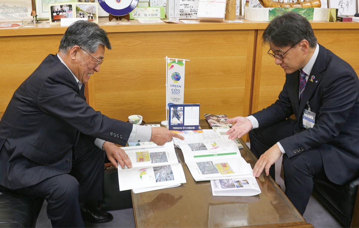 佐々田区長（右）に事業完了の報告をする岩澤さん（左）