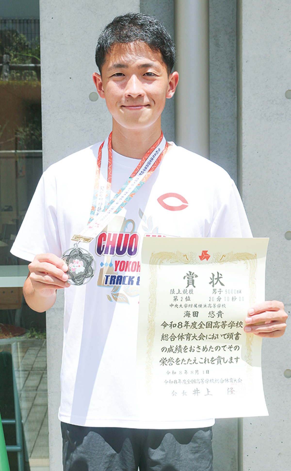 賞状とメダルを手にする海田さん