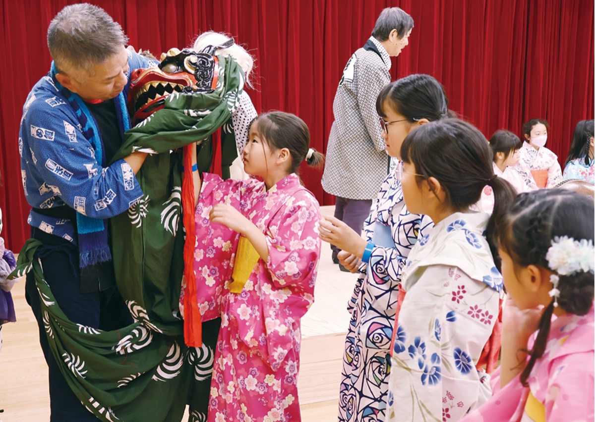 都筑区郷土芸能保存連合会のメンバーから、獅子舞などについて学ぶ子どもたち(区提供)