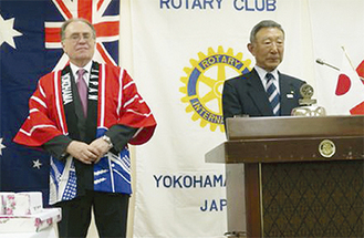 贈られた法被を着て喜ぶ大使（左）と倉本会長