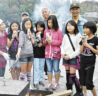 地域住民と一緒に焼き芋を楽しむ児童たち