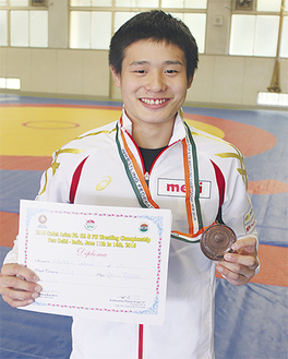 銅メダルと賞状を手に笑顔の林選手