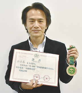 賞状とメダルを手にする松本さん