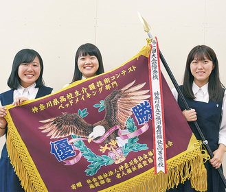 優勝旗を手にする親川さん、太田尾さん、佐川さん（左から）