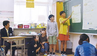 区役所職員（左）を前に発表する児童たち
