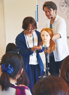 小澤さん（右）の指導でヘアアレンジを体験する参加者
