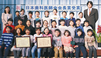 ４年生児童と江口さん（上段右）、鈴木校長（同左）