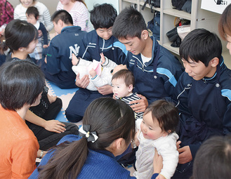 赤ちゃんを抱っこする生徒たち
