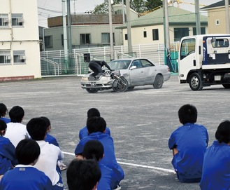 自転車と自動車の衝突事故の再現を見て、恐怖を体感する生徒たち