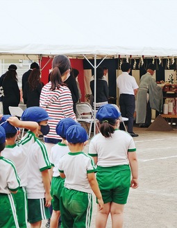 テントの中で行われる地鎮祭を見守る園児