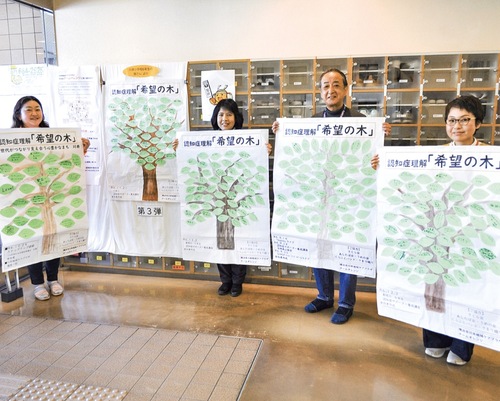 完成した希望の木を持つケアプラザの職員