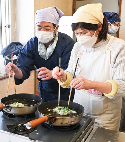 春菊の揚げ方を飯田さん（左）がアドバイス