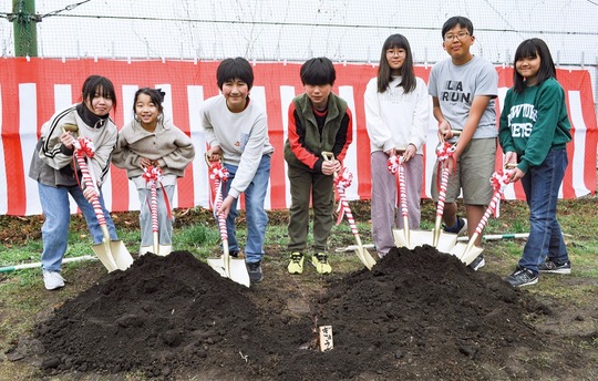 植樹式に参加した子どもたちと、手前に植えられた苗木の「ぎょうざ」