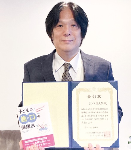 会長表彰の賞状と自著を持つ江口さん