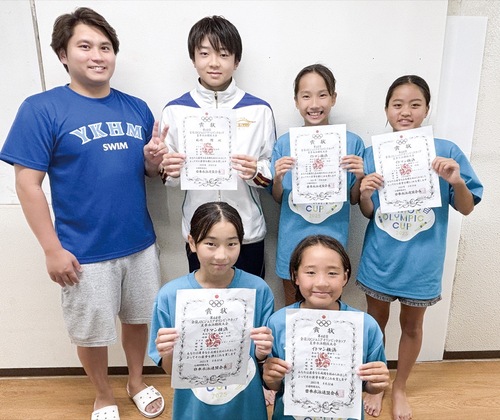 賞状を手にする選手と近藤コーチ