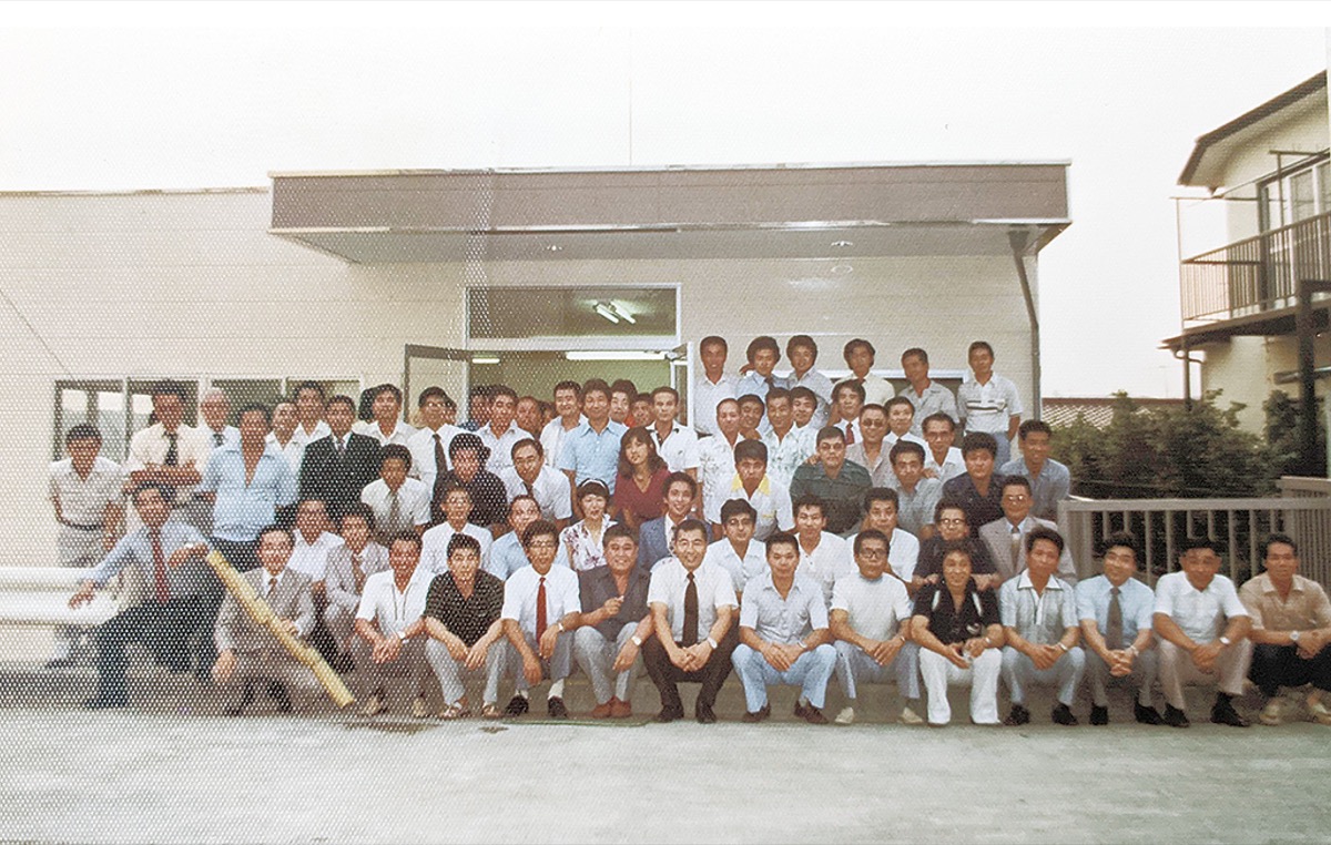 新社屋が竣工し、従業員や関係者で記念撮影(1980年)