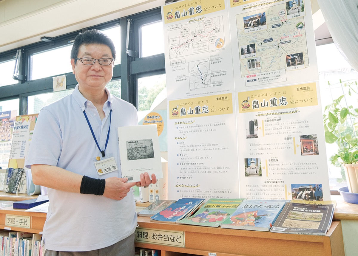 住民が作成した小説を手にする古屋館長