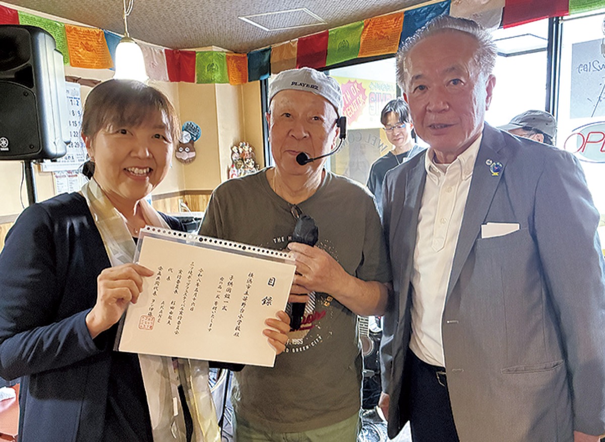 実行委員長の杉田由起夫さん(右)と伊藤さん(中央)から西山校長に目録が渡された