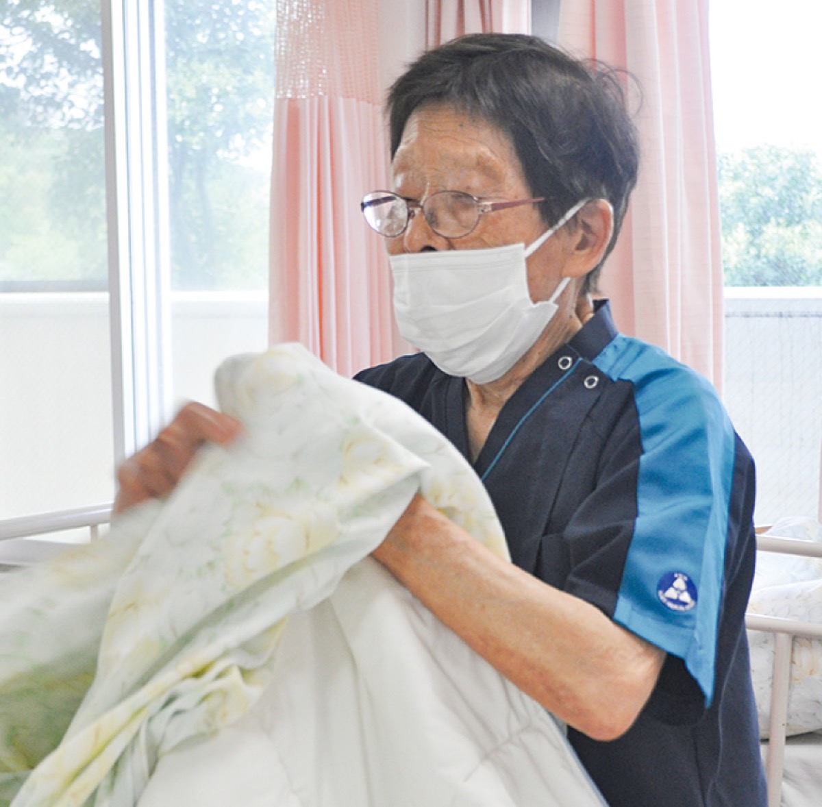 患者のベッドを整える安藤さん