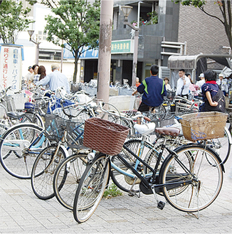 広場中央にずらりと並ぶ自転車。広場に自転車で乗り入れる人も