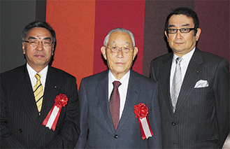 お祝いを受けた小澤氏（左）、田村氏（中）と弥郡会長
