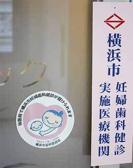 妊婦歯科健診が受けられる横浜市歯科医師会所属の医院はイラスト入りステッカー（左）が目印