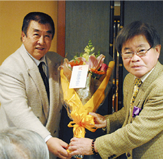 江野本長会長から花束を贈られた伊藤さん（左）
