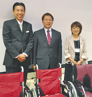 贈られた車椅子の前で（右から）森山さん・飯田理事長・本庄さん