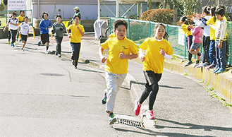 沿道の声援を受けながら走る児童たち