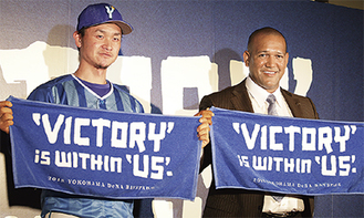 新スローガンが書かれたタオルを手にするラミレス監督（右）と大和選手
