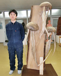 木で「くらげ」を表現したという木彫作品と並ぶ橋本さん