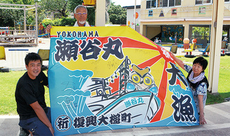 大漁旗を掲げる露木理事長（左）ら