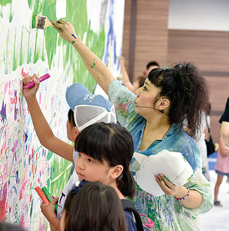 子どもたちと絵を描く蟹江さん（右）