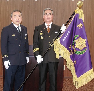 瀬谷消防署の安平博署長（左）から表彰旗を受け取った鈴木団長