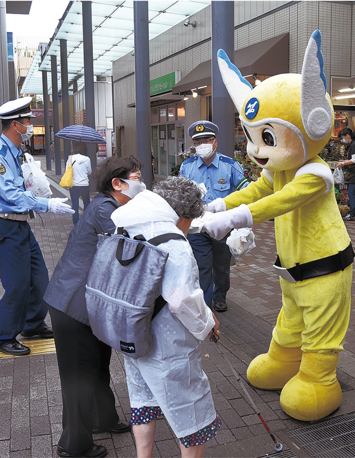 ピーガルくんが啓発グッズを手渡す