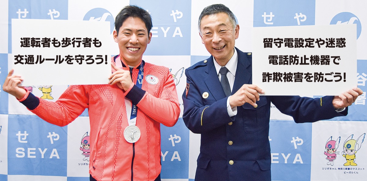 詐欺防止や交通安全を呼びかけるプラカードを持つ村田署長と本多選手